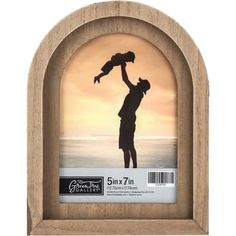 a wooden frame with a silhouette of a man holding a child in his arms and the sun