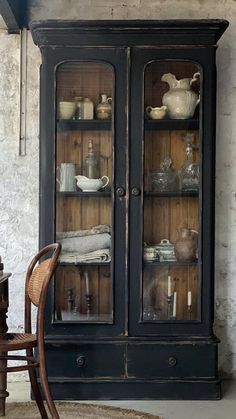 an old fashioned china cabinet with glass doors