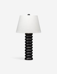 a lamp that is sitting on top of a white table cloth with a black spiral design