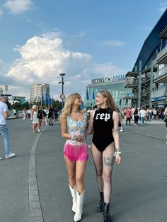 two women walking down the street with one wearing a bathing suit and the other in short shorts