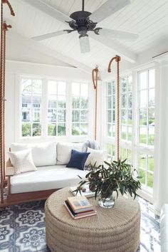 a living room filled with furniture and a ceiling fan in the middle of the room