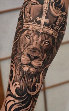 a lion with a crown on his head is shown in black and grey tattoo art