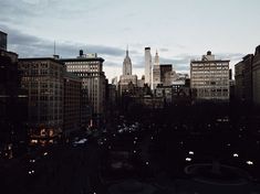 the city skyline is lit up at night, with skyscrapers in the foreground