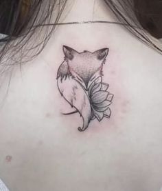 the back of a woman's neck with a tattoo of a fox on it