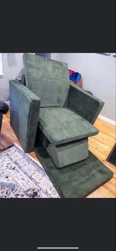 a green recliner chair sitting on top of a wooden floor next to a rug