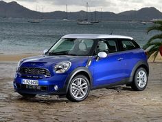 a blue mini cooper parked on the beach