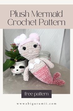 a crocheted mermaid doll sitting next to a potted plant