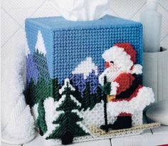 a knitted santa clause is standing next to a tissue dispenser