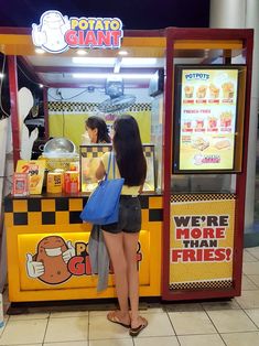 a woman standing in front of a vending machine at a fast food restaurant,