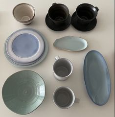 there are many plates and cups on the table together, including one with a saucer