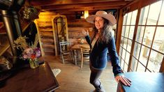 a woman wearing a cowboy hat standing next to a table