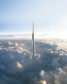 an aerial view of a tall skyscraper in the clouds