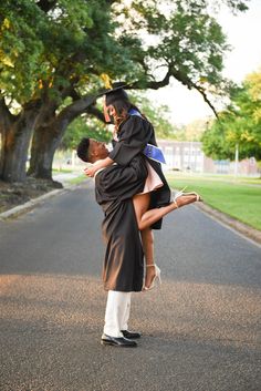 a man in a graduation cap and gown is carrying a woman on his back