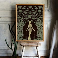 a wooden frame with an image of a woman standing in front of plants