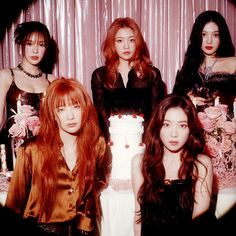 the girls are posing in front of a cake with candles on it and one girl has long red hair