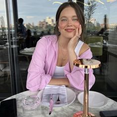 a woman sitting at a table in front of a window