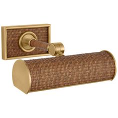 an antique brass toilet paper holder with wicker cover and gold finish on the front