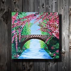 a painting of a bridge over a river with pink flowers on the trees and water below