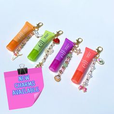 four different colored items are on a white surface with a pink tag that says new charms available