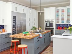 a kitchen with two stools in front of the island and an oven on the other side