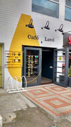 the front entrance to cafe, lavas and lemonade on a brick sidewalk in front of a white building