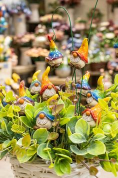 a basket filled with lots of colorful figurines sitting on top of green leaves