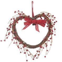 a heart shaped wreath with red berries hanging from it