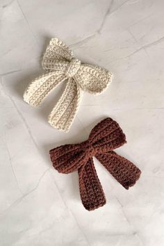 two crocheted bows are sitting on a white counter top next to each other