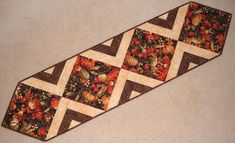 a close up of a tie on the ground with flowers and leaves in it's center