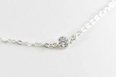 A tiny clear crystal twinkles on dainty yet strong sterling silver chains to create this elegant eye catching bracelet. The crystal measures 4mm in size. It is bezel set in 925 sterling silver. The crystal has been cut in a concave or diamond style, meaning it is flat in front and pointed at the back. This type of cut gives the crystal absolutely incredible sparkle. This bracelet is made to order. Please select your desired length upon checking out. Not quite sure? Just select an adjustable leng Minimalist Sterling Silver Bracelet In Diamond White, Minimalist Silver Bracelet With Single Diamond, Simple Silver Jewelry With A Single Diamond, Dainty Silver Sparkling Bracelets, Dainty Sparkling Silver Bracelets, Dainty Sparkling Silver Bracelet, Silver Sterling Bracelet With Single Diamond, Dainty Silver Bracelet, Solitaire Bracelet