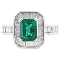 This ring is made in platinum and features an emerald cut, GIA certified emerald as the middle stone weighing 1.55 carats. The GIA certificate number is 2125281009. The ring also features 43 channel set, baguette cut diamonds weighing 1.23 carats. Gia Certified Platinum Emerald Baguette Ring, Gia Certified Baguette-cut Emerald Platinum Ring, Gia Certified Baguette Cut Emerald Platinum Ring, Classic Green Emerald Ring With Baguette Diamonds, Platinum Baguette Cut Green Emerald Ring, Green Emerald Cut Emerald Ring With Baguette Diamonds, Classic Green Diamond Ring With Baguette Diamonds, Rectangular Emerald Ring With Baguette Diamonds For Formal Events, Rectangular Emerald Ring With Baguette Diamonds For Formal Occasions