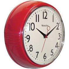 a red wall clock with black hands and numbers