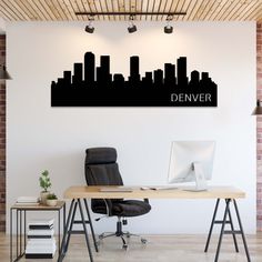 a desk with a computer on it in front of a city skyline wall decal