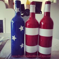 three red, white and blue wine bottles sitting on top of a table