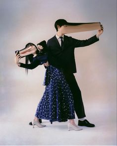 a man and woman dressed in formal clothing are posing for the camera with their arms around each other