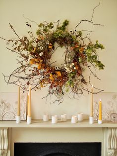 a fireplace with candles and a wreath on it