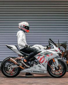 a man sitting on top of a silver motorcycle