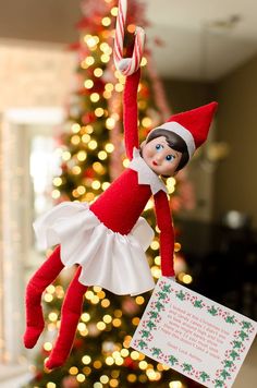 an elf is hanging from a christmas tree