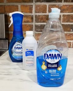 three bottles of dawn dish soap sitting on top of a counter