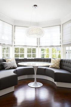 a living room filled with furniture and a round table in the middle of the room