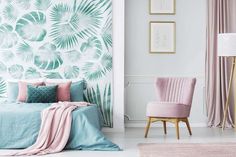 a bedroom decorated in pastel colors with palm leaves on the wall