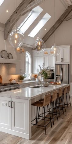 a kitchen with white cabinets and an island in the center, surrounded by stools