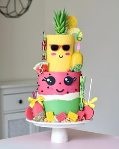 a colorful cake decorated with pineapples, watermelon, and other items