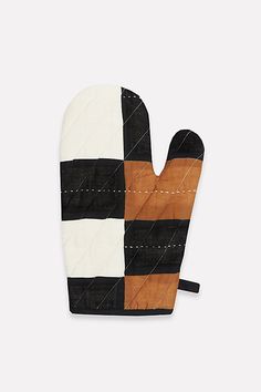 an oven mitt made out of black, white and brown fabric with stitching