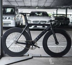 a bike parked in a parking garage next to other cars