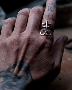 a person's hand with a ring on it that has the letter j in it