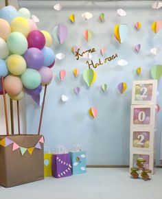 there are many balloons on the wall and some boxes in front of it with numbers