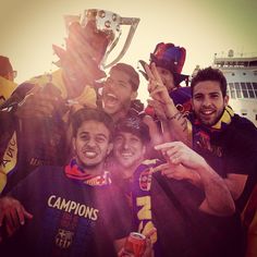 a group of men standing next to each other in front of a trophy and smiling