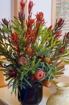 a vase filled with lots of flowers on top of a table