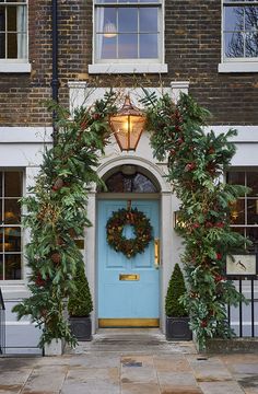 a blue front door with wreaths on it